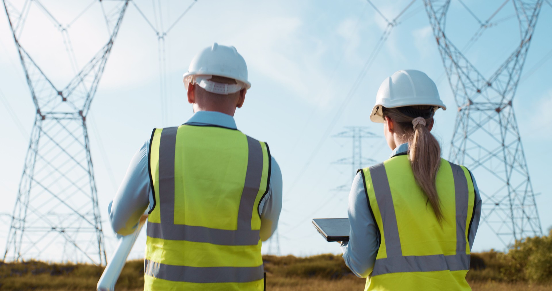 Teamwork, electrical engineering and tablet in power station with papers for electricity inspection and tower check. Construction, rear view and collaboration for energy distribution and maintenance